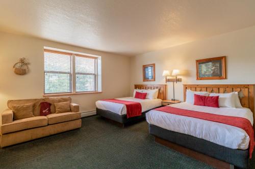 a hotel room with two beds and a couch at Wildwood Inn in Estes Park