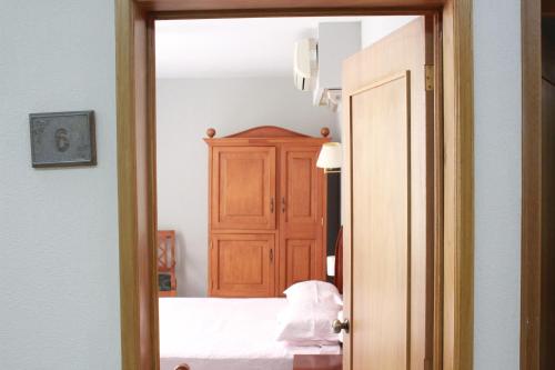 a bedroom with a bed and a wooden cabinet at Hotel Gran Domo in León