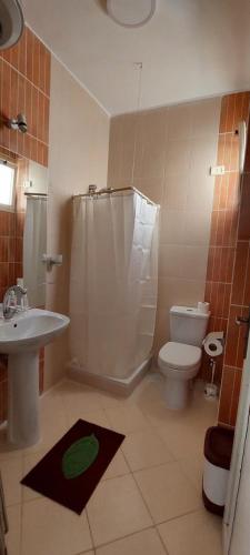 uma casa de banho com um WC, um chuveiro e um lavatório. em Villages road & promenade apartments em Hurghada