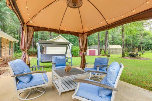 a group of chairs and a table under an umbrella at Dog-Friendly Alabama Retreat with Patio and Fire Pit! in Semmes