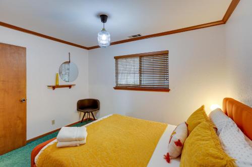 a bedroom with a bed with a yellow blanket at Rimforest Retreat with Fireplace and Mountain Views! in Rimforest