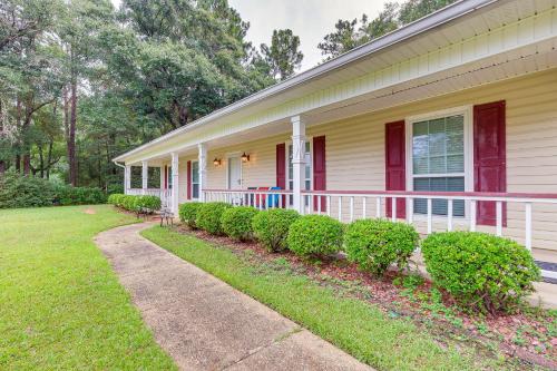 a house with a porch and bushes in front of it at Dog-Friendly Alabama Retreat with Patio and Fire Pit! in Semmes