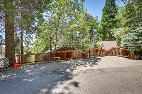 a wooden fence in a driveway with trees at Rimforest Retreat with Fireplace and Mountain Views! in Rimforest