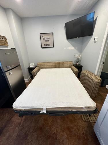 a hospital room with a bed and a flat screen tv at Twelve Oaks modern independent apartment in Tampa