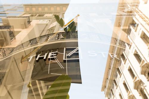 un riflesso di un edificio con un cartello sopra di Athens The L7 Str - Luxury Boutique Collection Hotel ad Atene