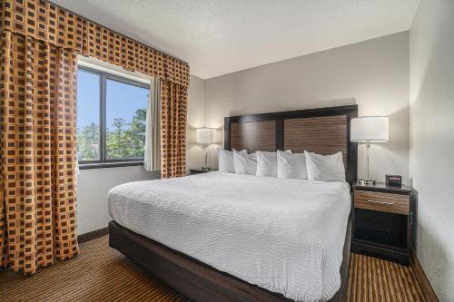 a hotel room with a bed and a window at Days Inn & Suites by Wyndham Traverse City in Traverse City