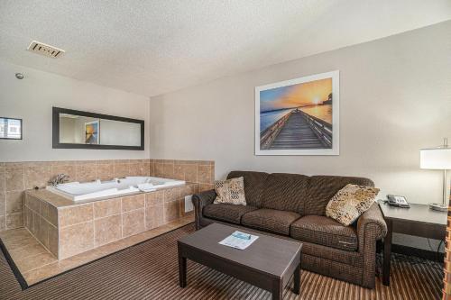 a living room with a couch and a bath tub at Days Inn & Suites by Wyndham Traverse City in Traverse City
