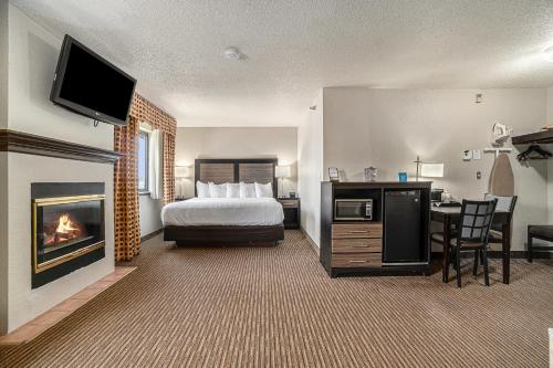 a hotel room with a bed and a fireplace at Days Inn & Suites by Wyndham Traverse City in Traverse City