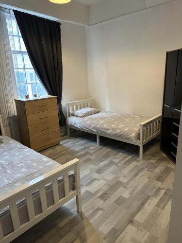 a bedroom with two beds and a dresser and a window at Central London location, close to bars restaurants and train stations in London
