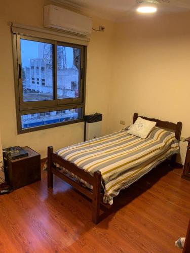 um quarto com uma cama e uma grande janela em Departamento céntrico amueblado - 4 personas em Concordia