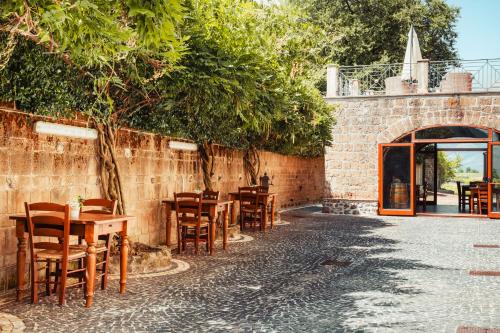 a group of tables and chairs next to a brick wall at COUNTRY HOUSE LE VIGNE b&b in Galluccio