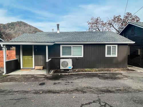 a house with a green door and a driveway at Waterfront River Apartments in Rogue River