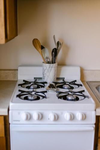 a white stove top oven with a container of utensils at Waterfront River Apartments in Rogue River