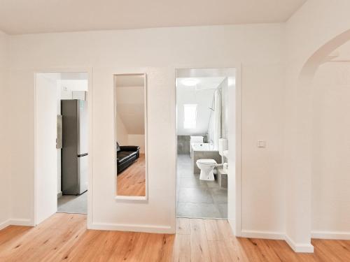 a white room with a mirror and a kitchen at RAJ Living - 3 and 4 Room Apartments in Duisburg