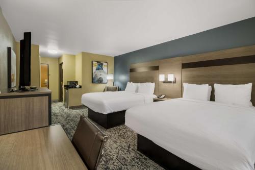 a hotel room with two beds and a flat screen tv at Best Western Temple Inn & Suites in Temple