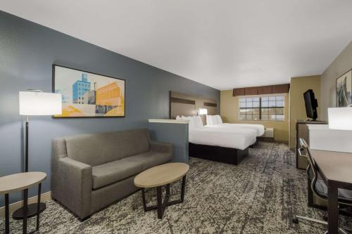 a hotel room with a bed and a bed and a couch at Best Western Temple Inn & Suites in Temple