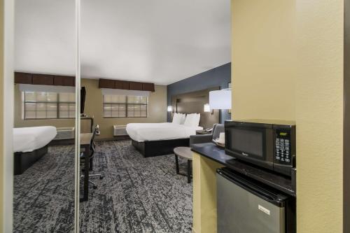 a hotel room with two beds and a microwave at Best Western Temple Inn & Suites in Temple