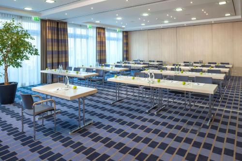 a large room with tables and chairs in it at Essential by Dorint Berlin-Adlershof in Berlin