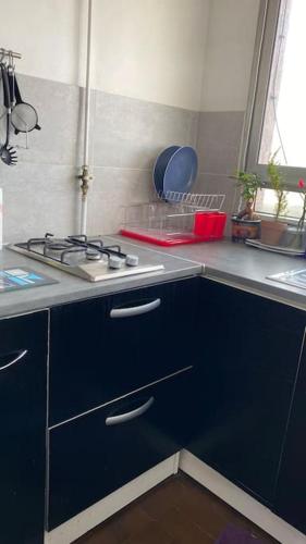 La cuisine est équipée de placards bleus et d'un four avec plaques de cuisson. dans l'établissement Nice loft with romantic view over the Eiffel tower, à Paris