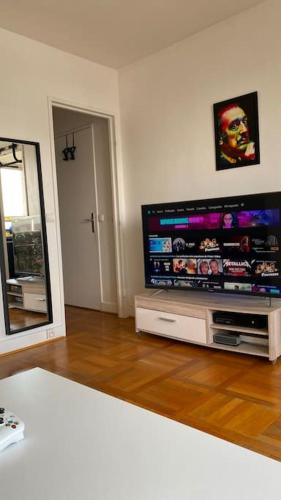 un salon avec une grande télévision à écran plat dans l'établissement Nice loft with romantic view over the Eiffel tower, à Paris