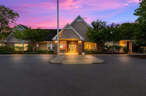 a house in a parking lot with a sunset at Sonesta ES Suites Parsippany Morris Plains in Parsippany