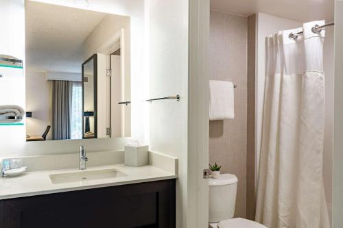 a bathroom with a sink and a toilet and a mirror at Sonesta ES Suites Parsippany Morris Plains in Parsippany