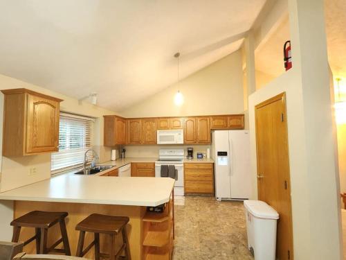 a kitchen with wooden cabinets and a white refrigerator at Pet friendly,3 Queen beds, One-Full bed with Fast free WIFI in Omaha