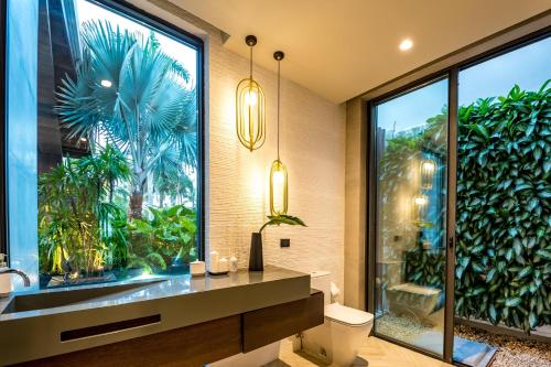 a bathroom with a toilet and a large window at Sunny Vacation Villa No 38 in San Rafael del Yuma