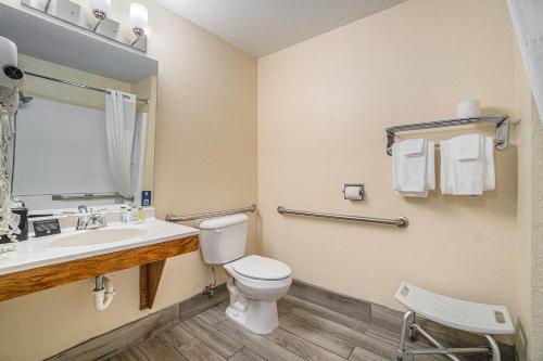 a bathroom with a toilet and a sink and a mirror at Days Inn & Suites by Wyndham Traverse City in Traverse City