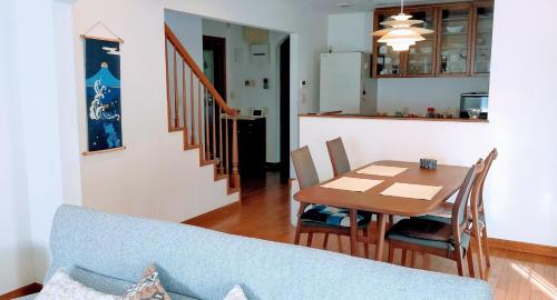 八王子的住宿－Guest house with host Takao SORA- Vacation STAY 13000，厨房以及带蓝色沙发和桌子的用餐室。