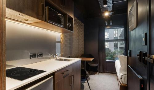 a small kitchen with a sink and a stove at Abstract Hotel & Residences in Auckland