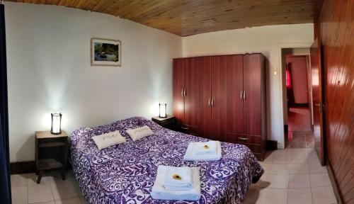 1 dormitorio con cama morada y armarios de madera en Casachocolate1 en Chacras de Coria
