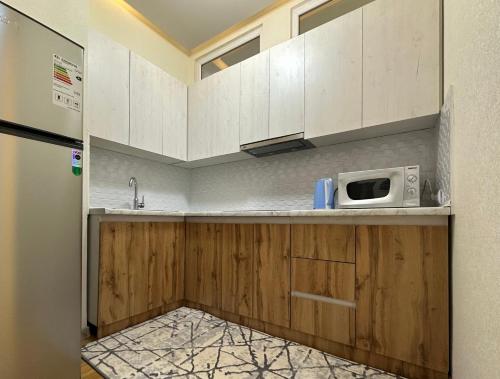a kitchen with white cabinets and a microwave at Dushanbe City View Apartments in Dushanbe