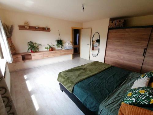 ein Schlafzimmer mit einem Bett in einem Zimmer mit Pflanzen in der Unterkunft Huis Rochelle in Bredene