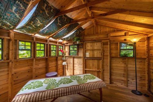 a bedroom in a wooden cabin with a bed in it at Opulent Waterfall House with Ocean Views in Haiku, Maui in Huelo
