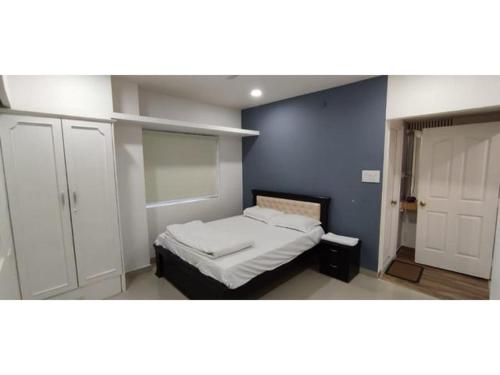 um quarto com uma cama e uma parede azul em B S Homes em Hyderabad
