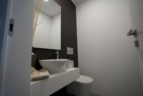 a bathroom with a sink and a toilet and a mirror at Esposende Resort - Golf, Beach, River, Tennis, Pool in Gemezes