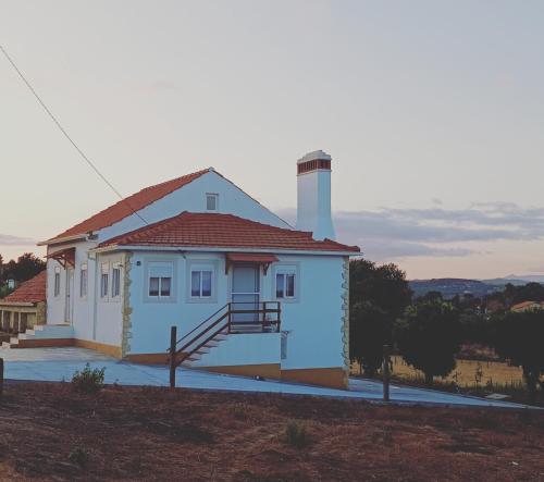 a small white house with a chimney on top at Casa dos pássaros in Carril
