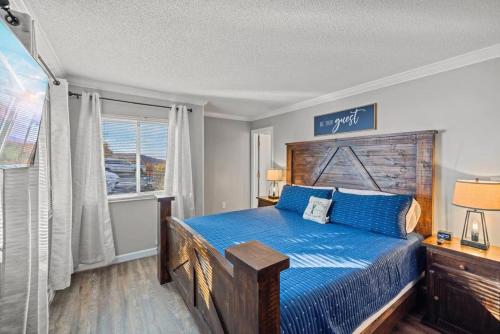 Un dormitorio con una cama azul y una ventana en Top of the Smokies en Gatlinburg