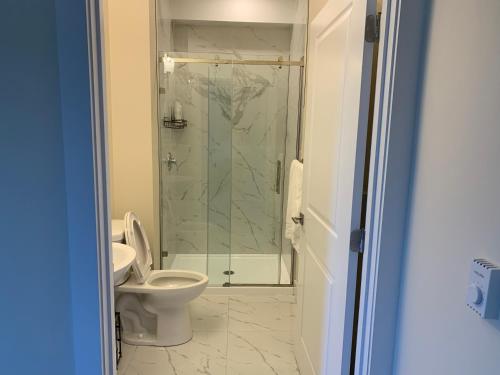 a bathroom with a toilet and a glass shower at 1 bedroom apartment in Halifax