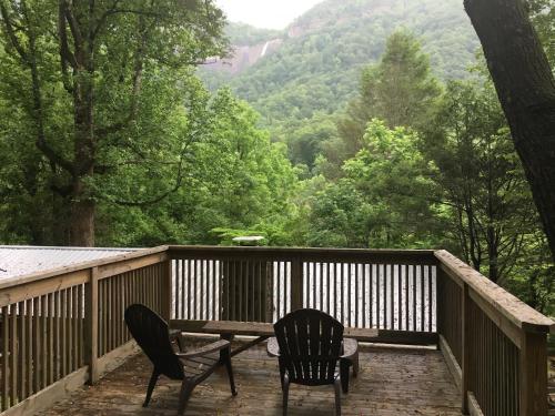 two chairs and a table on a deck with a view at Lazy Lodge with Waterfall View in Chimney Rock