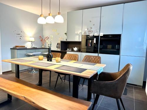 a kitchen with a table and chairs in a kitchen at Mein Apartment, Forest View mit Balkon und Klima, bis 10 Personen in Bad Kreuznach