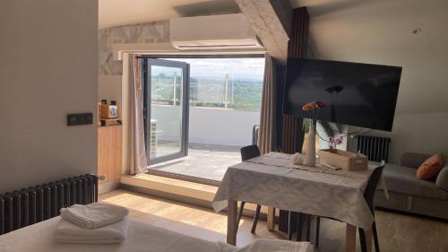 a living room with a table and a large window at Siente Muralla in Lugo