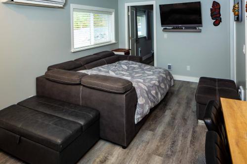 a bedroom with a bed and a couch and a chair at Chims Cabins - Port Alberni in Port Alberni