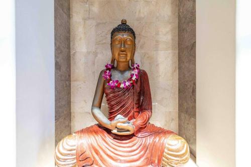 a statue of a woman sitting on the ground at Cliff House with Ocean Views in Haiku, Maui jungle in Huelo