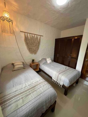 a bedroom with two beds and a chandelier at Departamento nuevo a estrenar! in Manzanillo