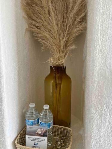 a vase and two bottles of water in a shelf at Departamento nuevo a estrenar! in Manzanillo