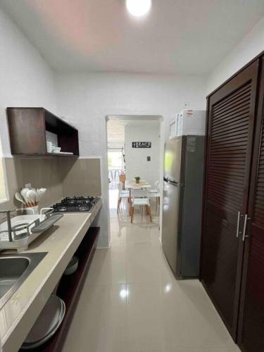 a kitchen with a stainless steel refrigerator and a table at Departamento nuevo a estrenar! in Manzanillo