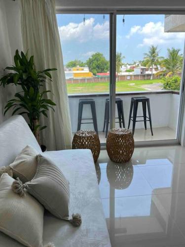 a living room with a couch and a large window at Departamento nuevo a estrenar! in Manzanillo