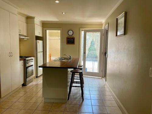 cocina con encimera, fregadero y taburete en Barnard street Cottage, en Bendigo